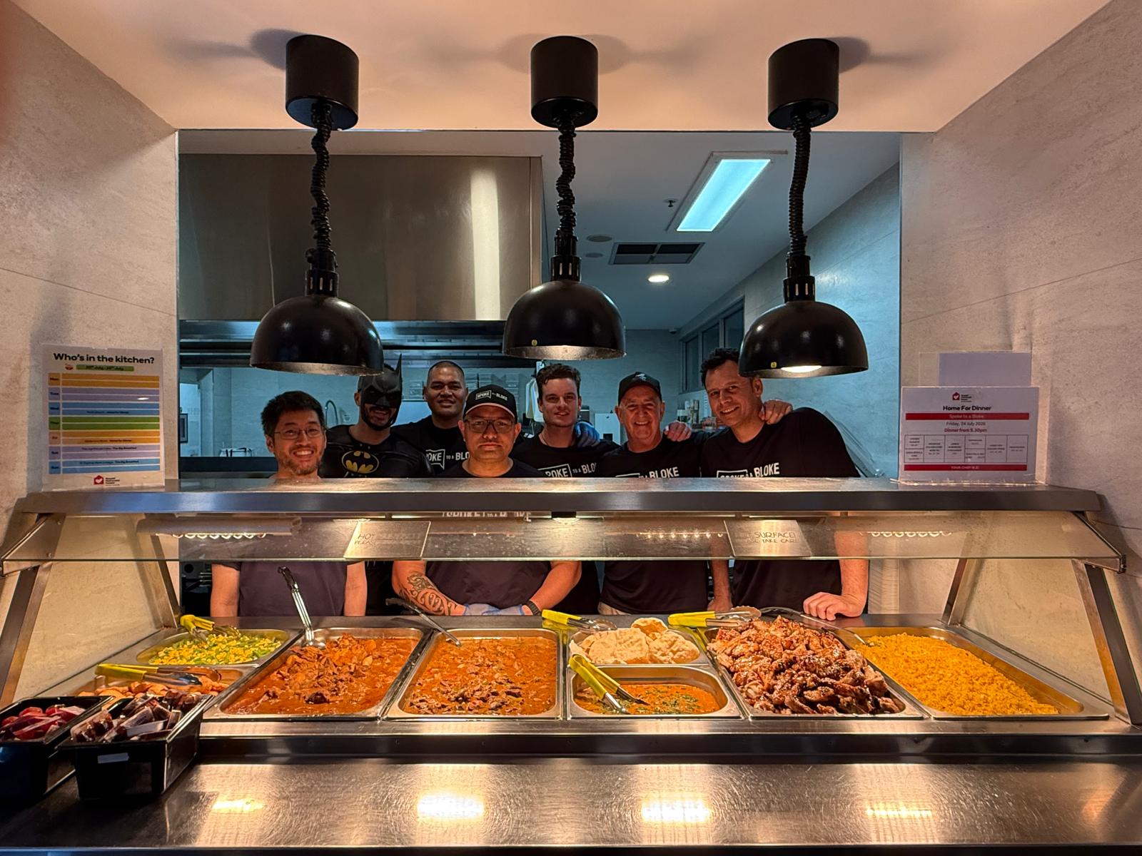 The Spoke to a Bloke crew behind the serving counter with a full spread of home-cooked meals