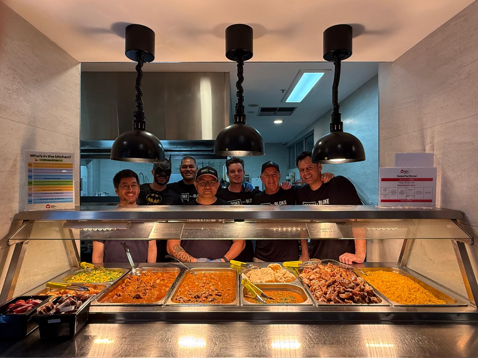 The full team of volunteers smiling behind the finished dinner service