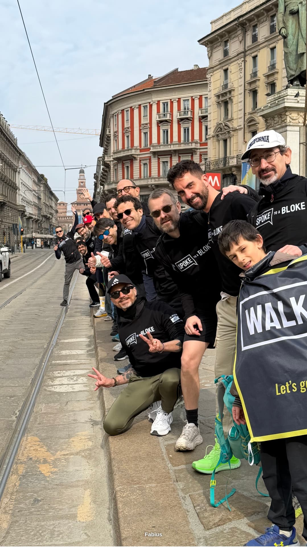 Line of Milan walkers in Spoke to a Bloke tops along a tram-lined street