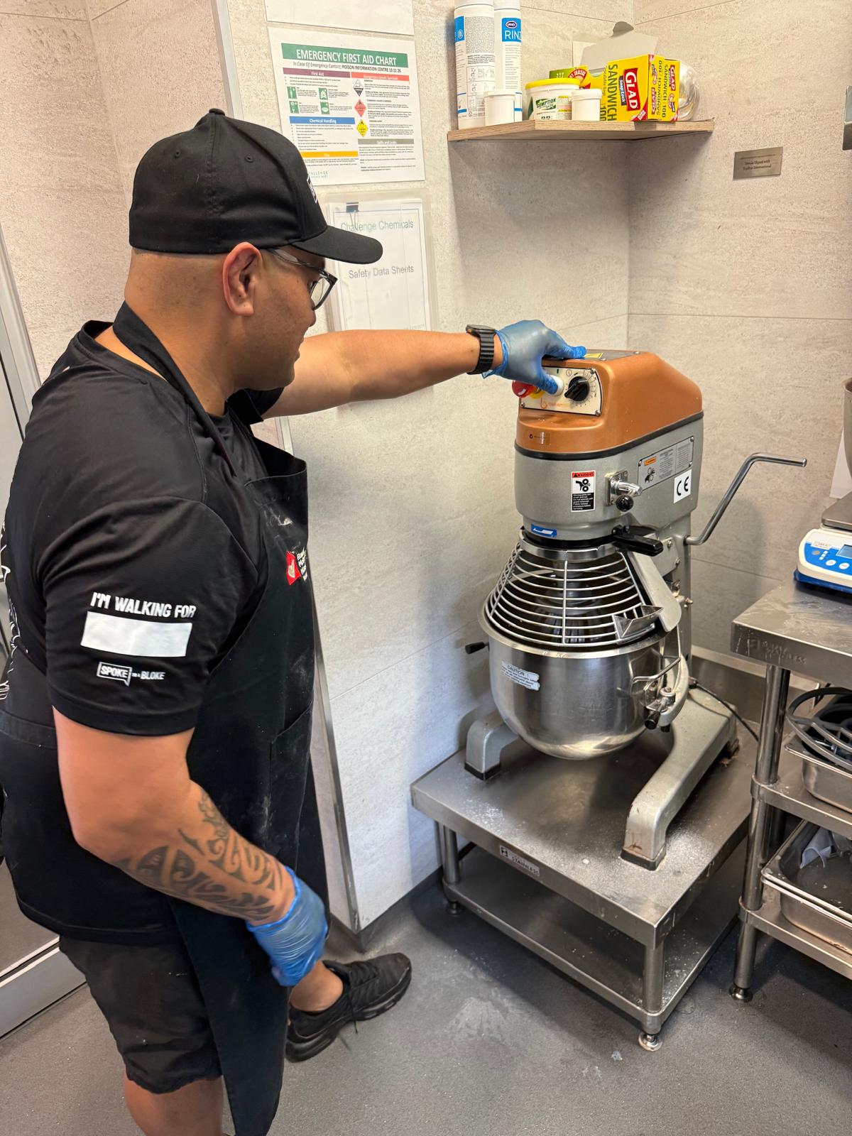 Volunteer setting the mixer while prepping the meal
