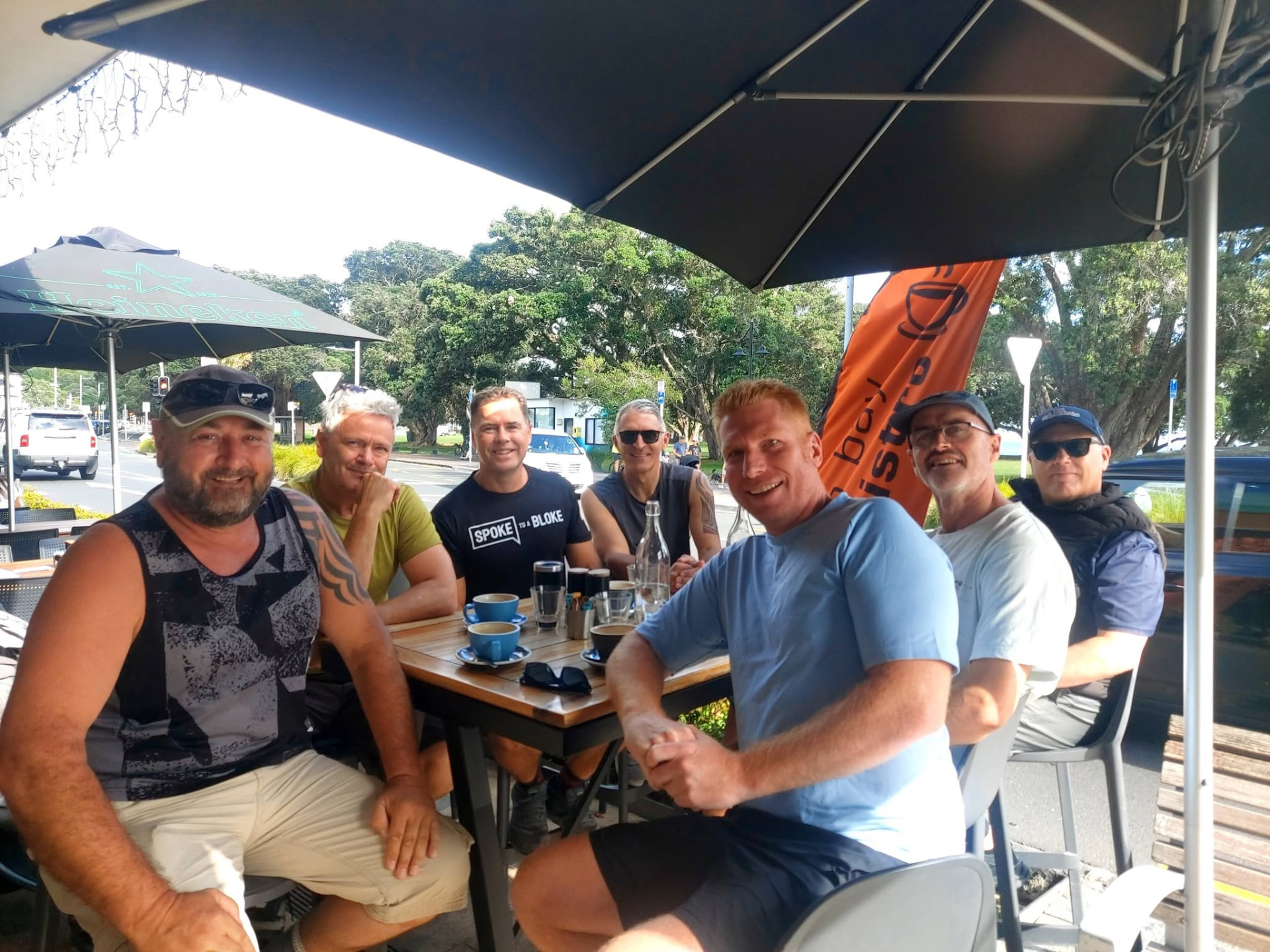 Morning Meetup group sharing coffee at a waterfront cafe in Auckland